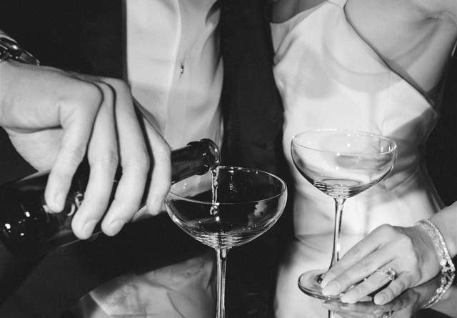 Bride and groom holding champagne glasses and groom pouring champagne at Virgin Hotels captured by Jeff Brummett