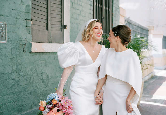 Brides sharing a joyful moment during their wedding reception at Virgin Hotels, with elegant decor and a lively atmosphere enhancing the celebration.