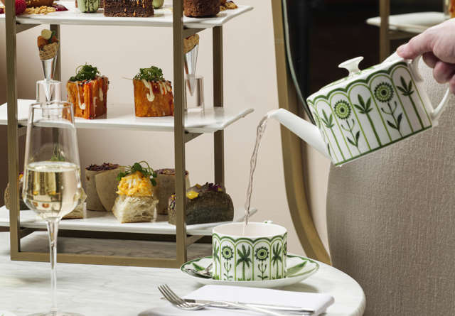 Afternoon tea spread with pastries, sandwiches, and tea service, elegantly presented at Virgin Hotels.