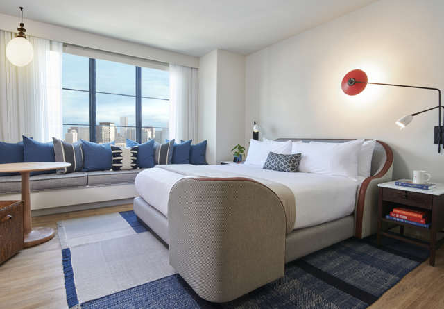 Chamber King room inside Virgin Hotels Nashville with a luxurious bed, modern furnishings, and large windows.