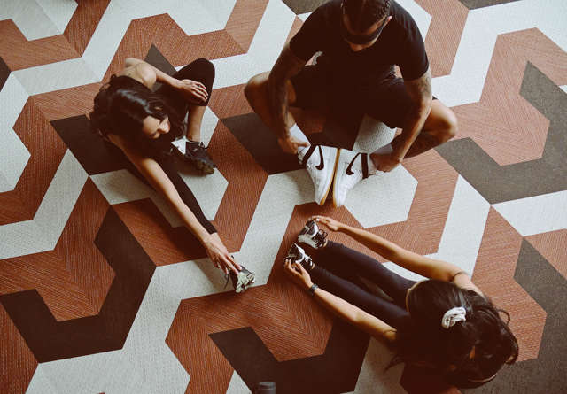 Group of people in workout gear stretching.