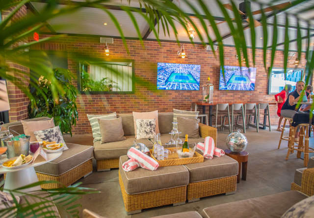 Cozy seating area at Virgin Hotels with a plush, covered sofa and accent pillows, set against a stylish backdrop, creating a comfortable and inviting atmosphere.